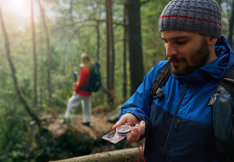 Man met kompas tijdes een sterloop en oriëntatie tocht. - Oxtarn Clinics & Adventures